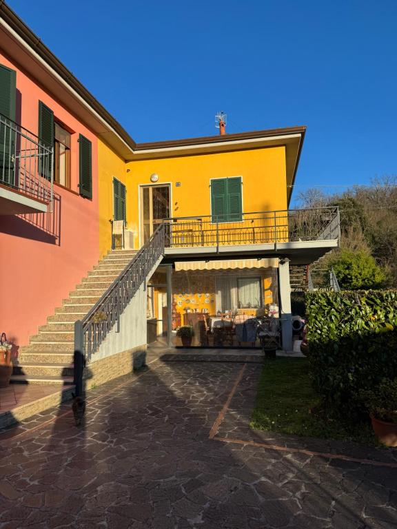 a yellow house with a staircase in front of it at Cà Turi Sarzana in Sarzana