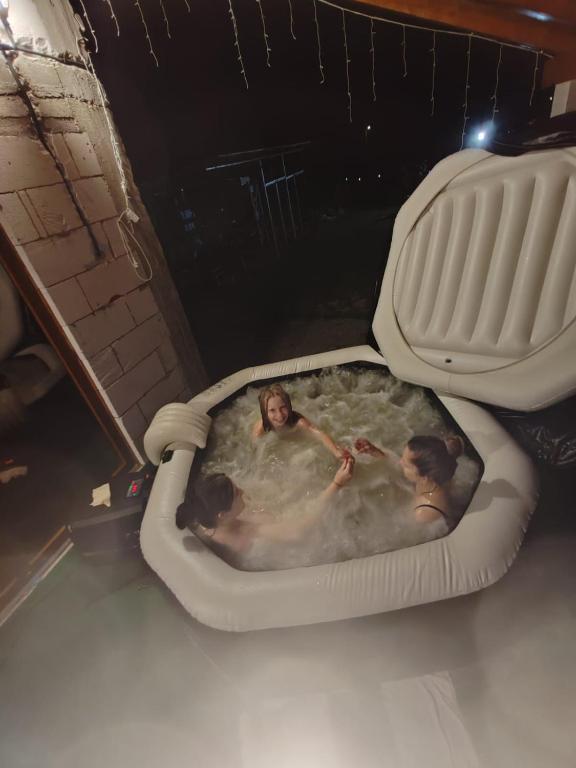 a group of people bathing in a hot tub at Căsuța din deal in Tranisu