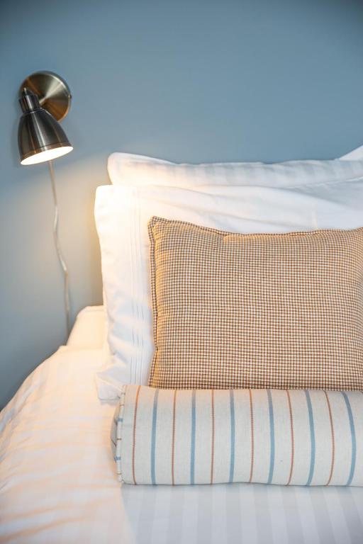 a bed with a pillow and a lamp on it at Vakantiewoning Conterdijk 13 in Koksijde