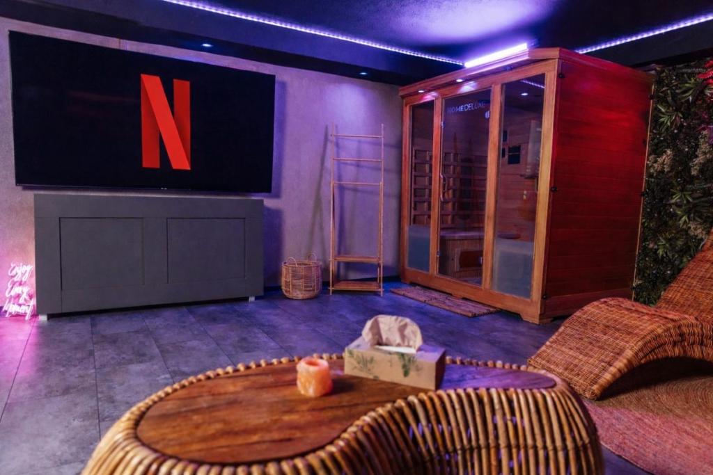 a room with a stage with a large tv and a table at Melin Spa Suite – Wellness, Garten in Marl