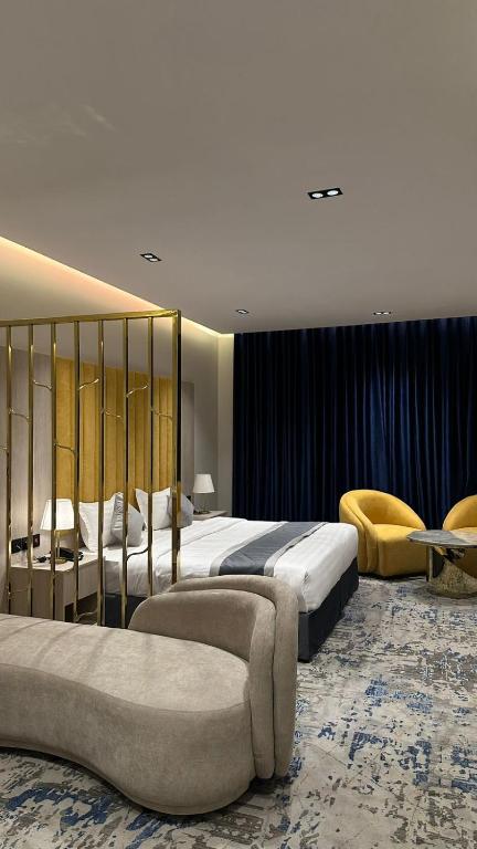 a hotel room with two beds and a couch at Al Seef Hotel in Al-ʿUla