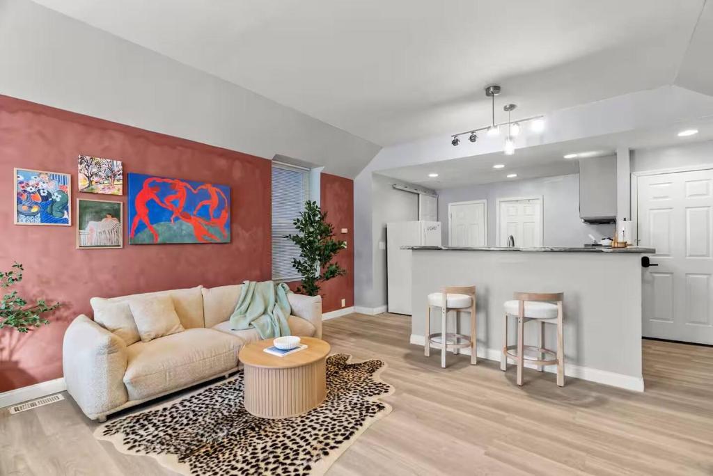 a living room with a couch and a kitchen at Boutique Studio Hideaway Near Forest Park in Saint Louis