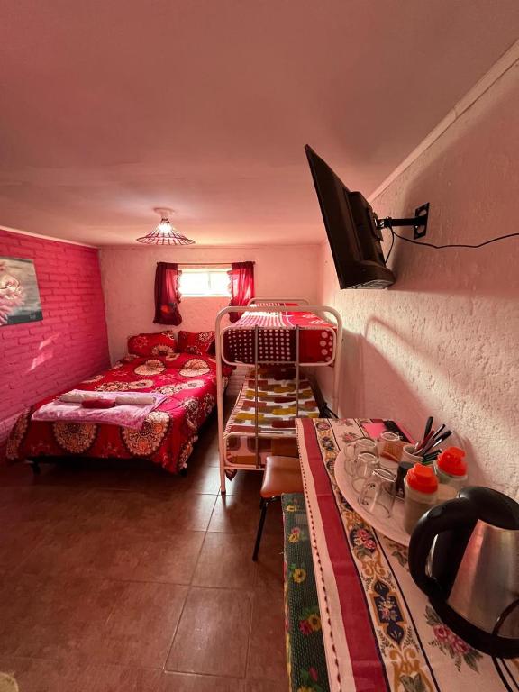 a room with two beds and a table in a room at Dormis C la Familia in Malargüe
