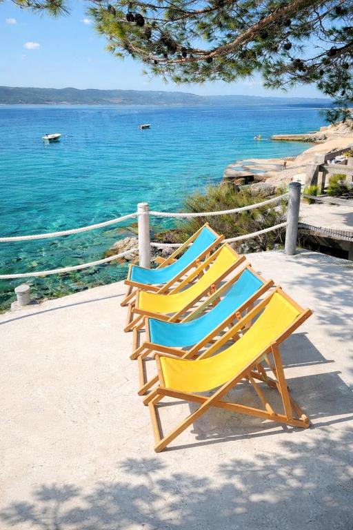 two yellow and blue chairs sitting next to the ocean at Family home away on the beach, free parking at the house in Marusici 