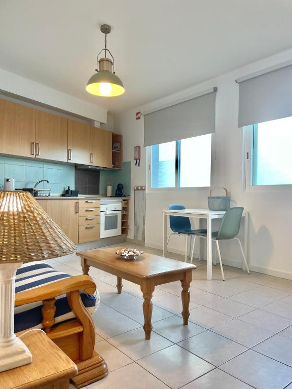 a living room with a table and a kitchen at Bayview Apartment 106 in Albufeira