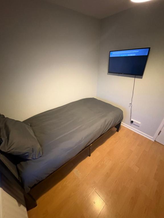 a bedroom with a bed and a flat screen tv at Cosy room 6 T Gatwick in Crawley