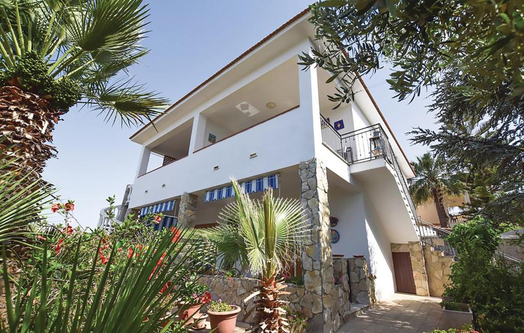 a large white house with plants in front of it at S.Giorgio Apartments in Sciacca