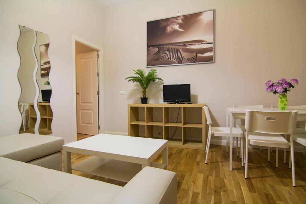 - un salon avec une table et un canapé dans l'établissement Apartamentos Aloha 2 Centro El Puerto de Santa Maria, à El Puerto de Santa María