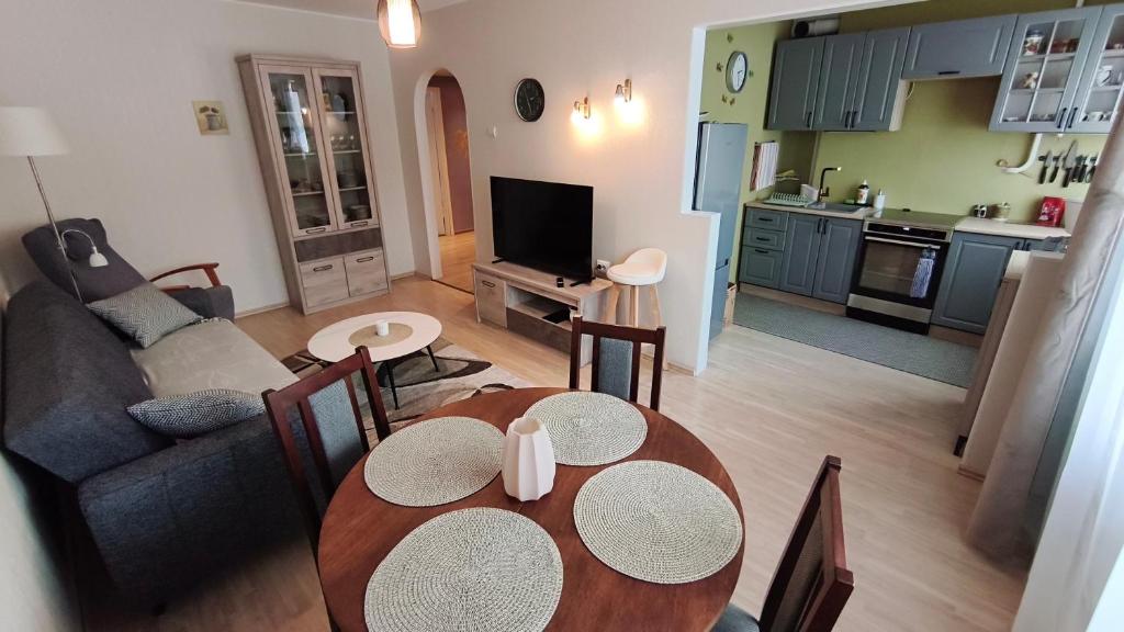 a living room with a dining room table and a kitchen at Vilde Apartment in Tallinn