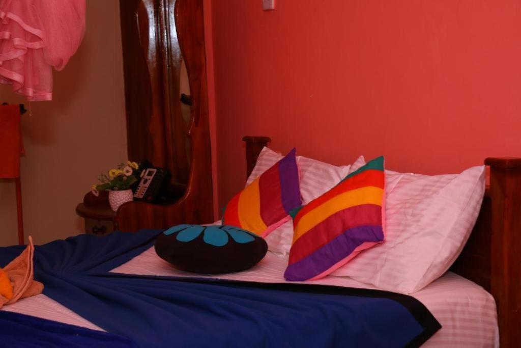 a bed with colorful pillows on top of it at Ella Little Heaven guest in Ella