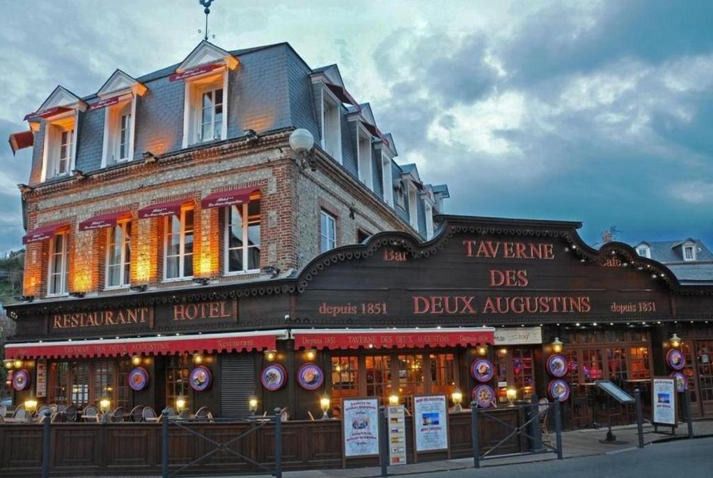 a building with a sign on the side of it at L'Hôtel de la Taverne in Étretat