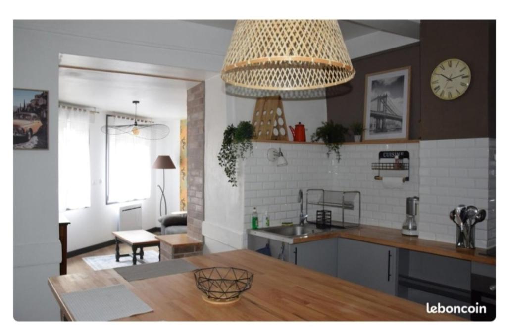 a kitchen and living room with a large chandelier at Maison Terreaux in Vaux-en-Bugey