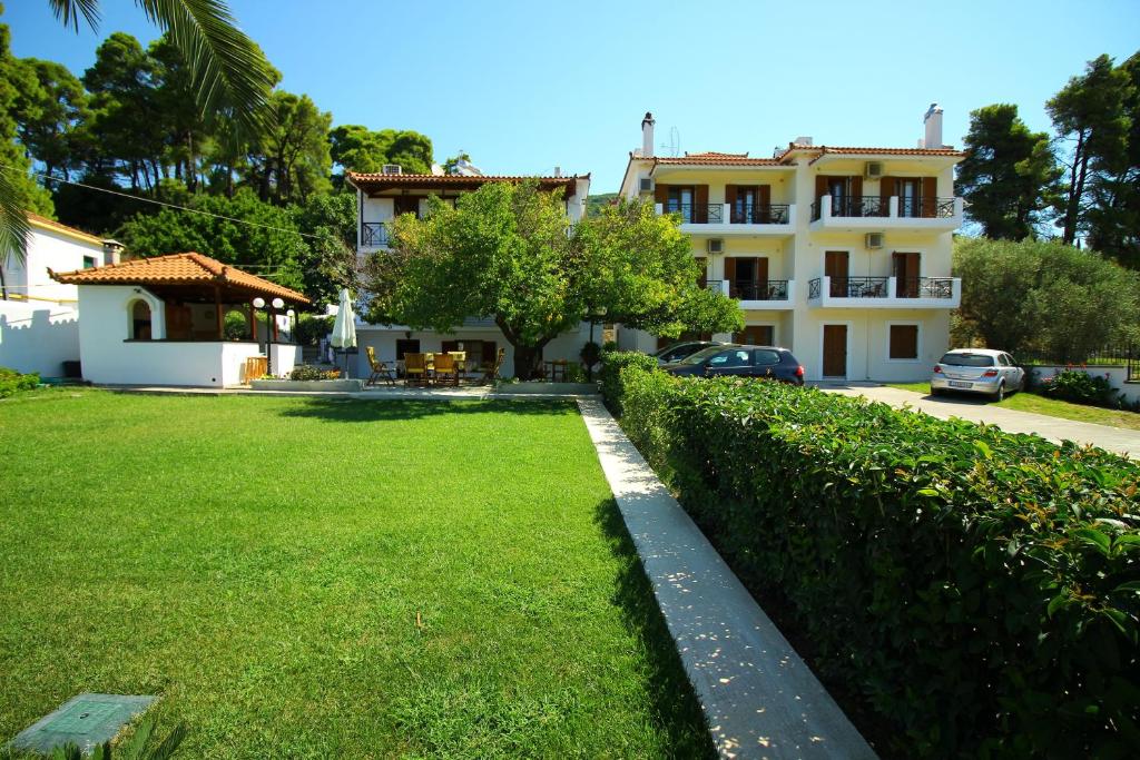 a large yard with a building and a house at Olympion Apartments in Stafylos