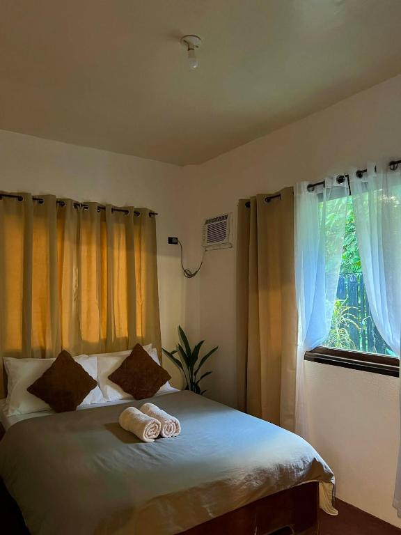 a bedroom with a bed with two towels on it at Paians 2BR Home, across Cloud 9, General Luna in Catangnan