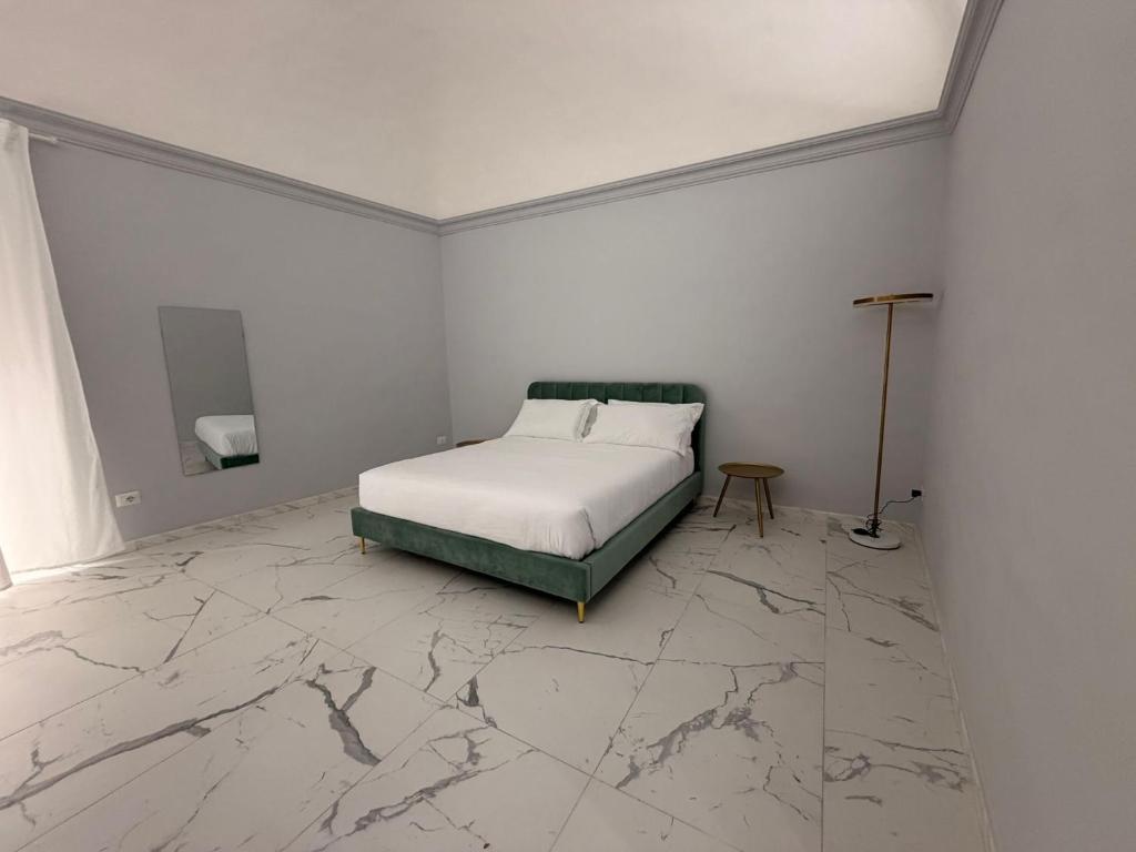 a bedroom with a bed and a marble floor at Vulcano Rooms 3 in Catania
