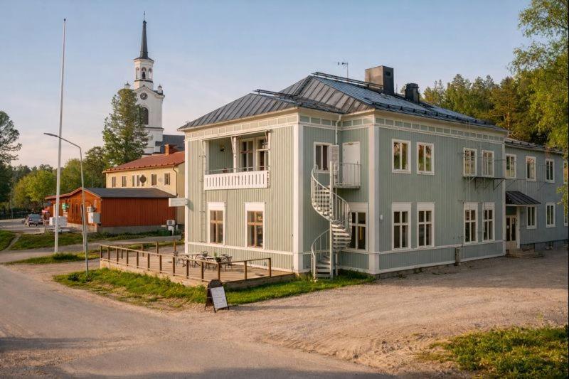 a large blue building with a tower in the background at Wärdshuset Liden in Liden