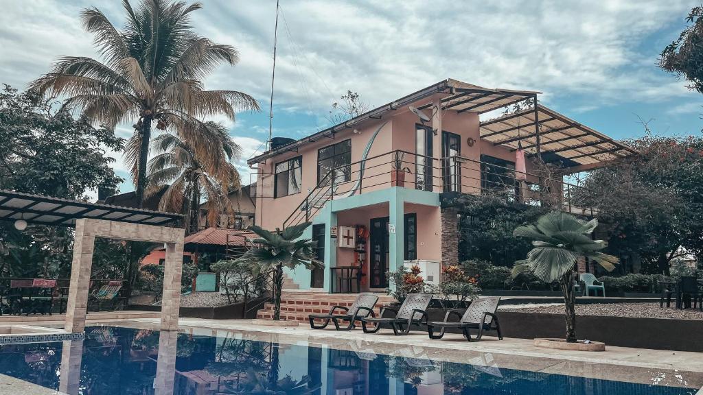 a pink house with a swimming pool in front of it at New Western Llanos Stay in Acacías