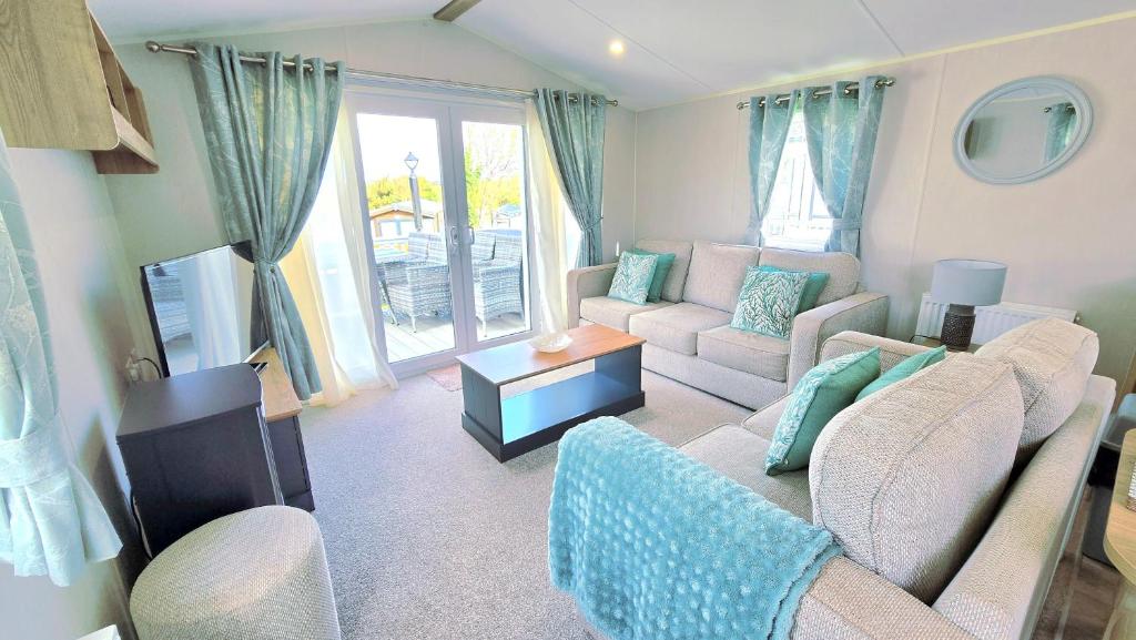 a living room with a couch and a table at Cornwall Caravan Retreat 3 Crantock in Crantock