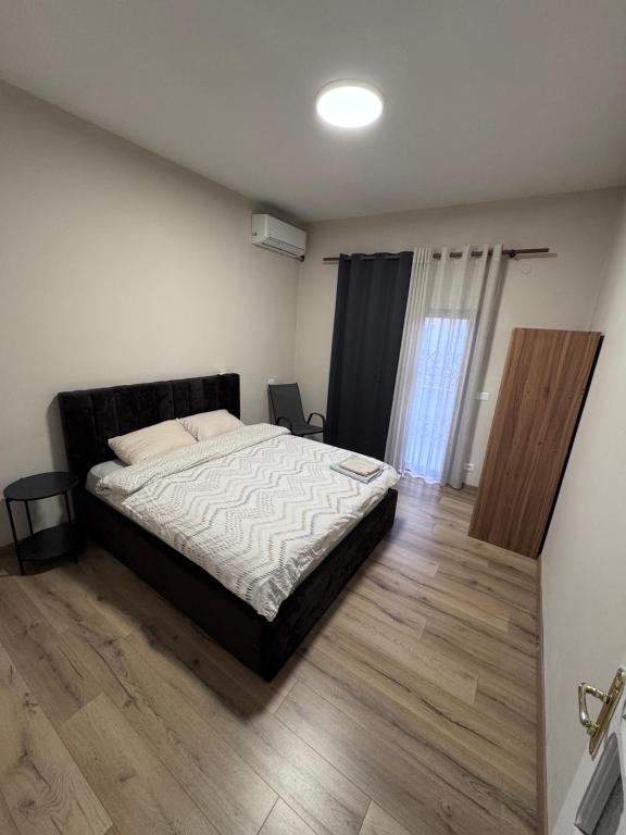 a bedroom with a bed and a wooden floor at Hostel Villa EFES Private Rooms in Tirana