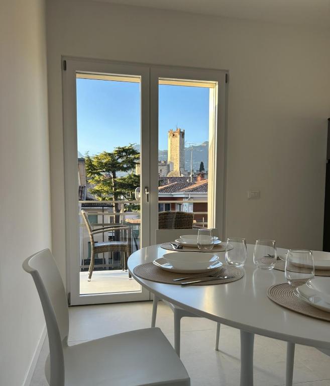 a white dining room with a table and chairs and a window at Casa Nane in Malcesine