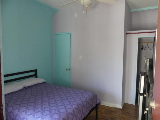 a bedroom with a purple bed and a ceiling fan at Wilshire Orange Hotel in Los Angeles