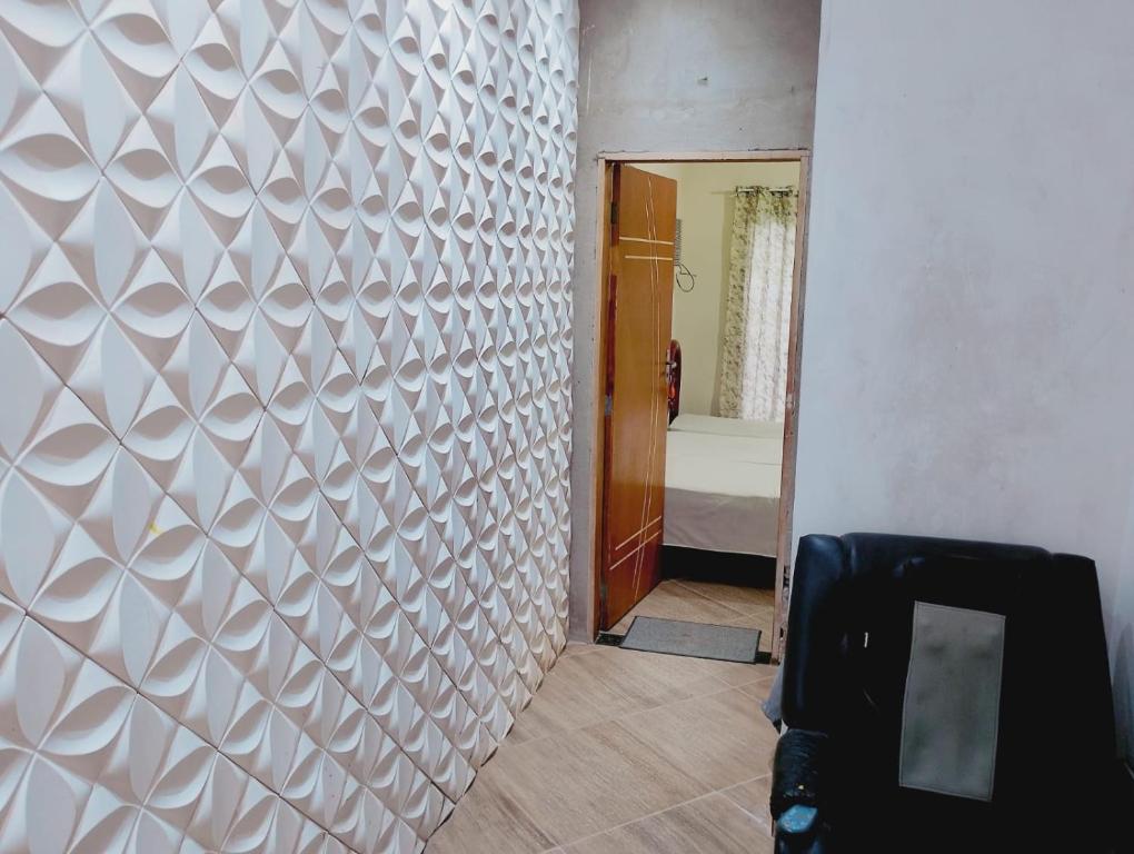 a hallway with a white patterned wall in a room at pousada benção in Aparecida