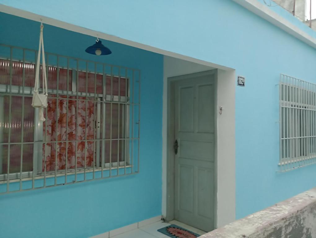 a room with a blue wall and a door at Refúgio da Aldeia - trabalho ou lazer! in São Pedro da Aldeia