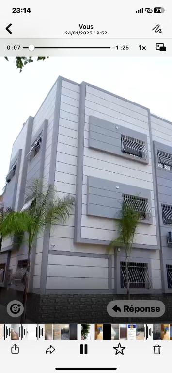 a white building with two trees in front of it at Maghrib ARABI OULED OUJIH in Kenitra