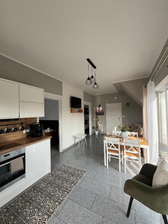 a kitchen and living room with a table and chairs at Apartamenty nad Przełomem Białki Apartments in a nature reserve Przełom Białki in Nowa Biała