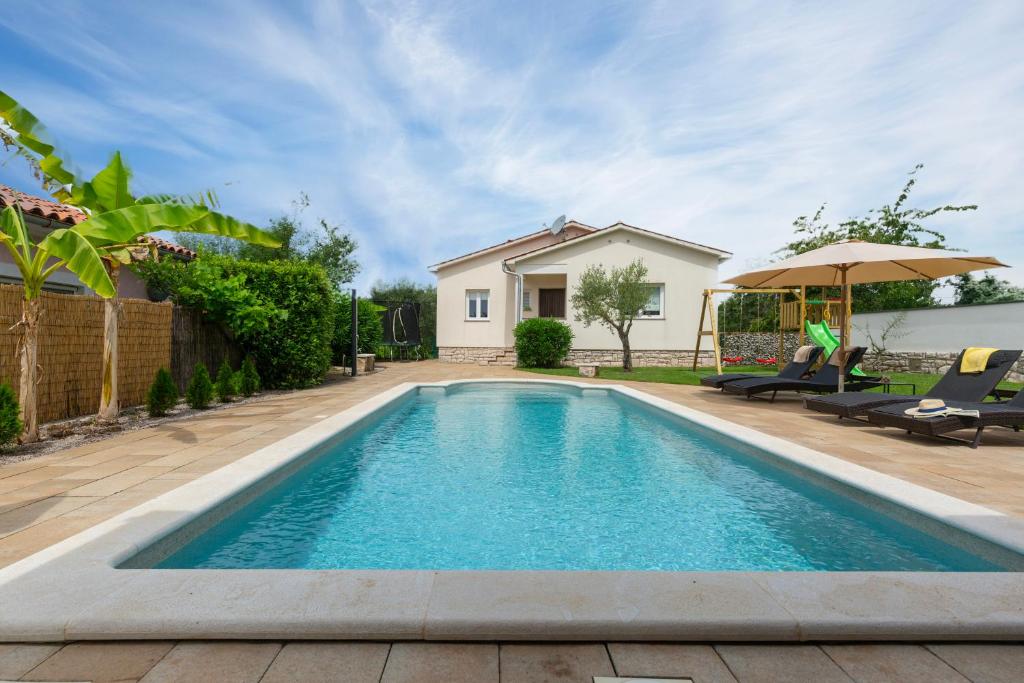a swimming pool in the backyard of a house at Villa Luka Nedešćina in Nedeščina