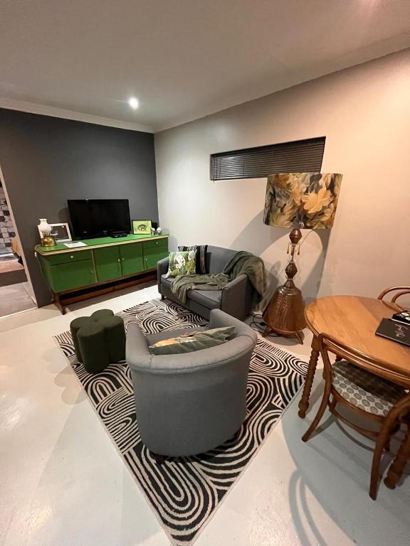 a living room with a couch and a table at Otista Self-Catering Cottage Bloemfontein in Bloemfontein