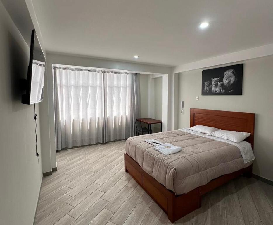 a bedroom with a bed and a flat screen tv at Hotel Altavista in Abancay