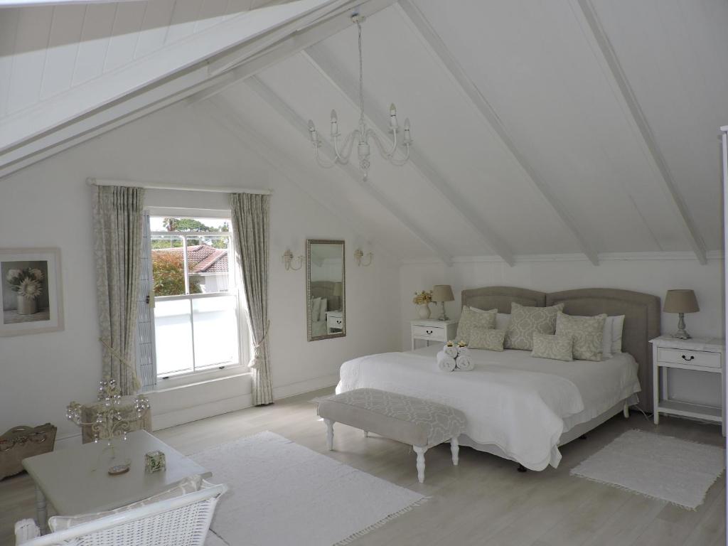 a white bedroom with a large bed and a window at Riverlea in Cape Town
