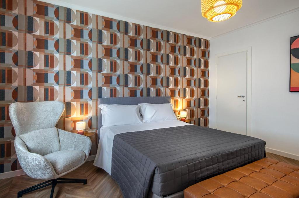 a bedroom with a bed and a chair at Enia Rooms in Nola