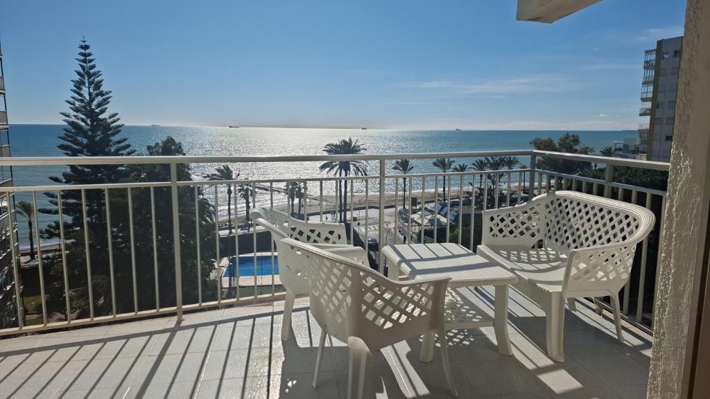 a balcony with a table and chairs and the ocean at Frontal con vistas in Benicàssim