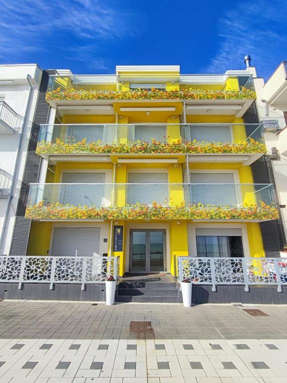 a yellow building with flowers on the balconies at Yellow Dream B&B in Torre Melissa