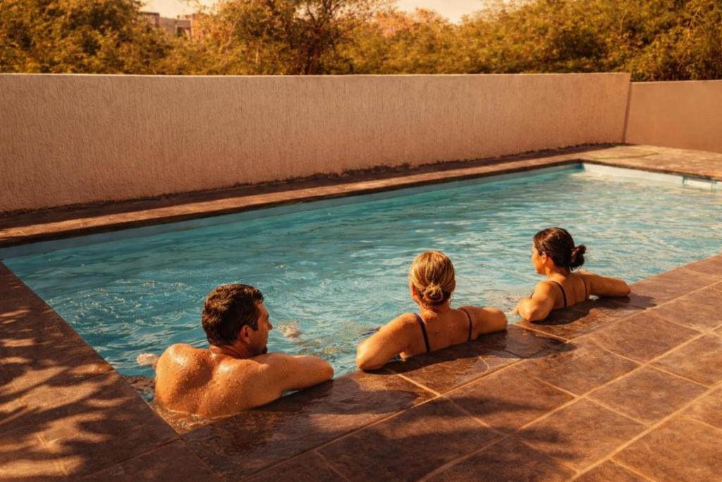 a group of people sitting in a swimming pool at Sunset Haven in Flic-en-Flac