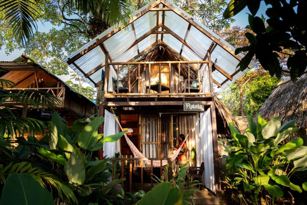 a tree house with a woman standing outside of it at Mangle House Cabañas Ladrilleros in Buenaventura