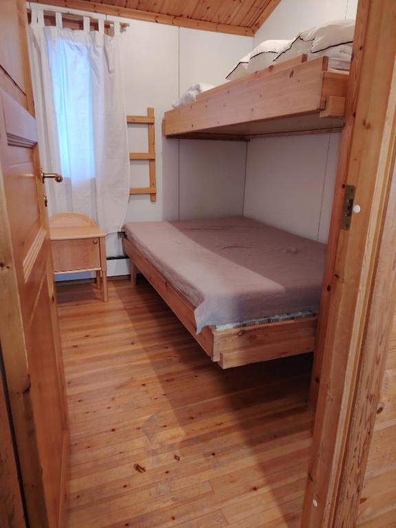 a bunk bed in a room with a wooden floor at Riihitupa 10 in Muurame