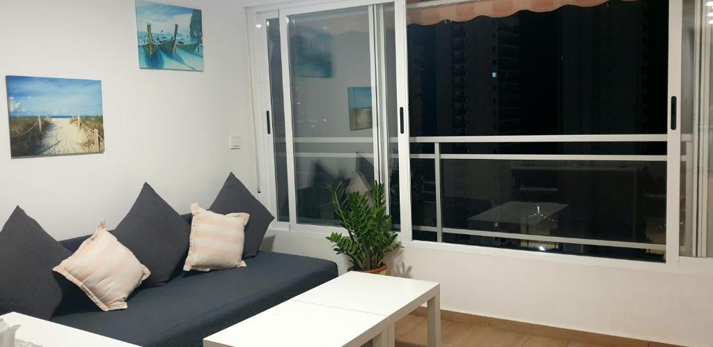 a living room with a couch and a window at Paradise Ducado Benidorm Vistas al Mar, Piscina, Parking Gratis y Wifi 4 Persona in Benidorm