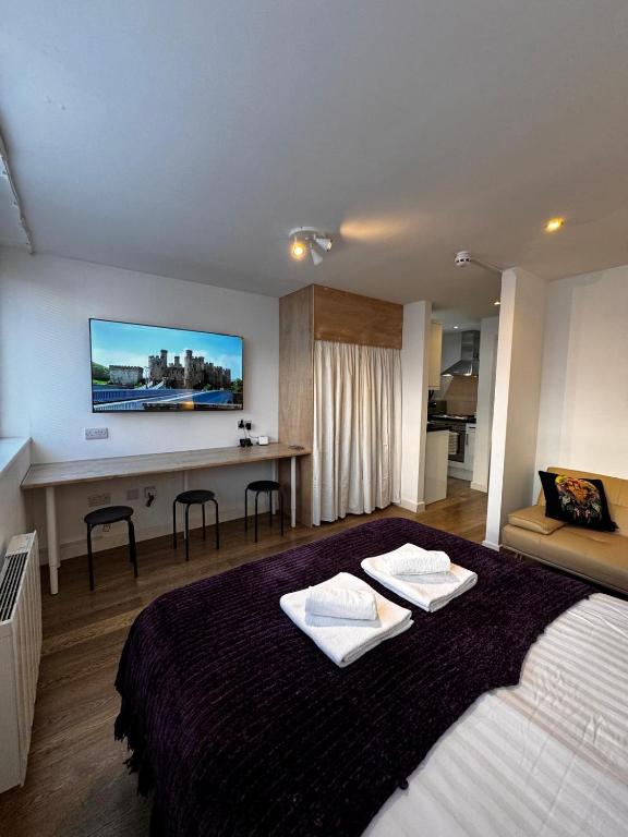 a bedroom with a large bed with two towels on it at Studio with Parking & Shops at Your Door in Andover