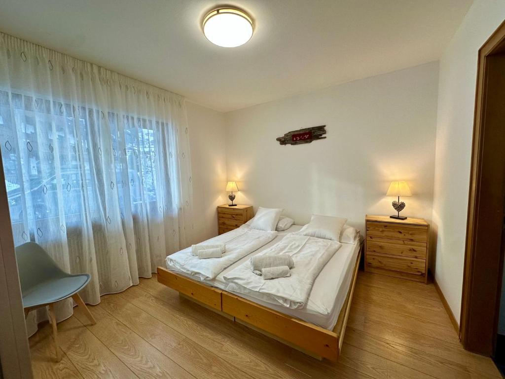 a bedroom with a large bed and a large window at Central Dolomites Atelier - 3 Bedrooms in Campitello di Fassa