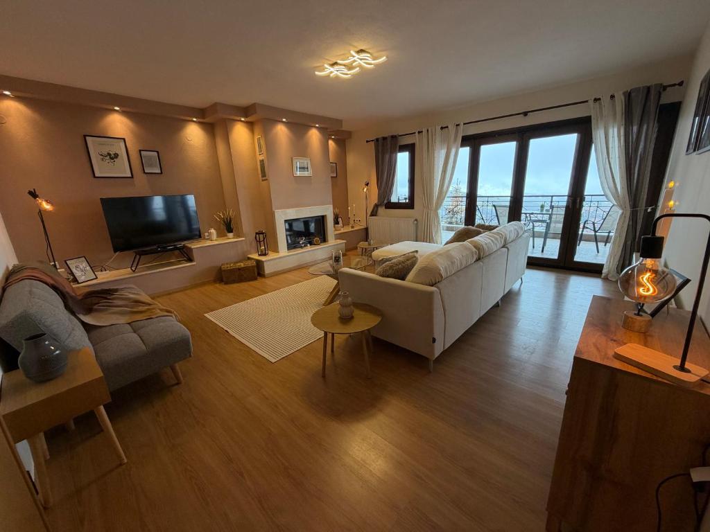a living room with a white couch and a television at The Watch Tower B in Siátista