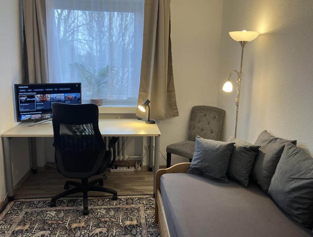 a living room with a couch and a desk with a computer at Am Biebricher Schloßpark in Wiesbaden