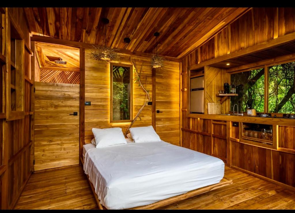 a bedroom with a bed in a wooden room at Pura selva tree house in Tamarindo