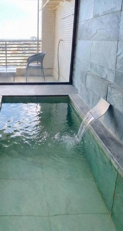 a swimming pool with a chair in the water at Capybara樓中樓湯屋 in Jiaoxi