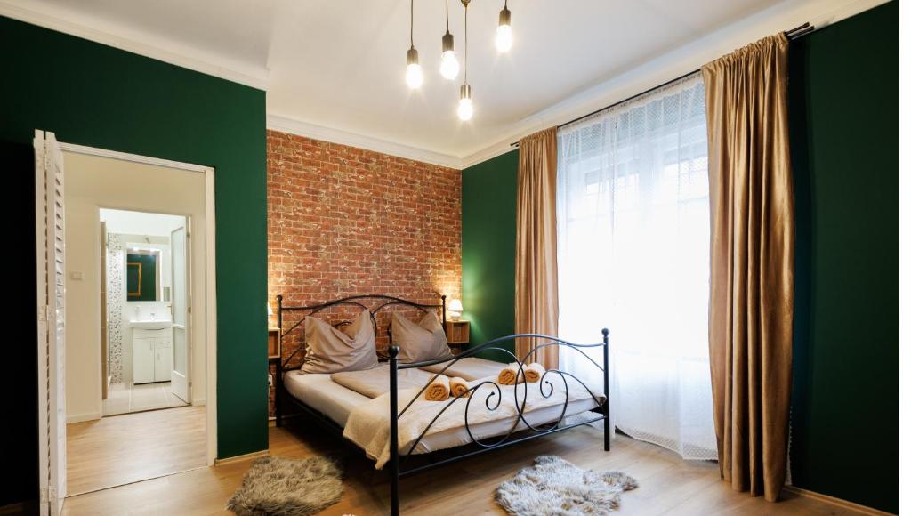 a bedroom with a bed and a green wall at Eperke Apartmanok in Balatonfüred