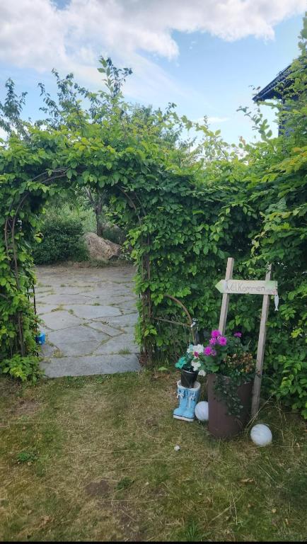 an arch with a cross and flowers in a yard at Kalveld aparment 2 in Lillesand