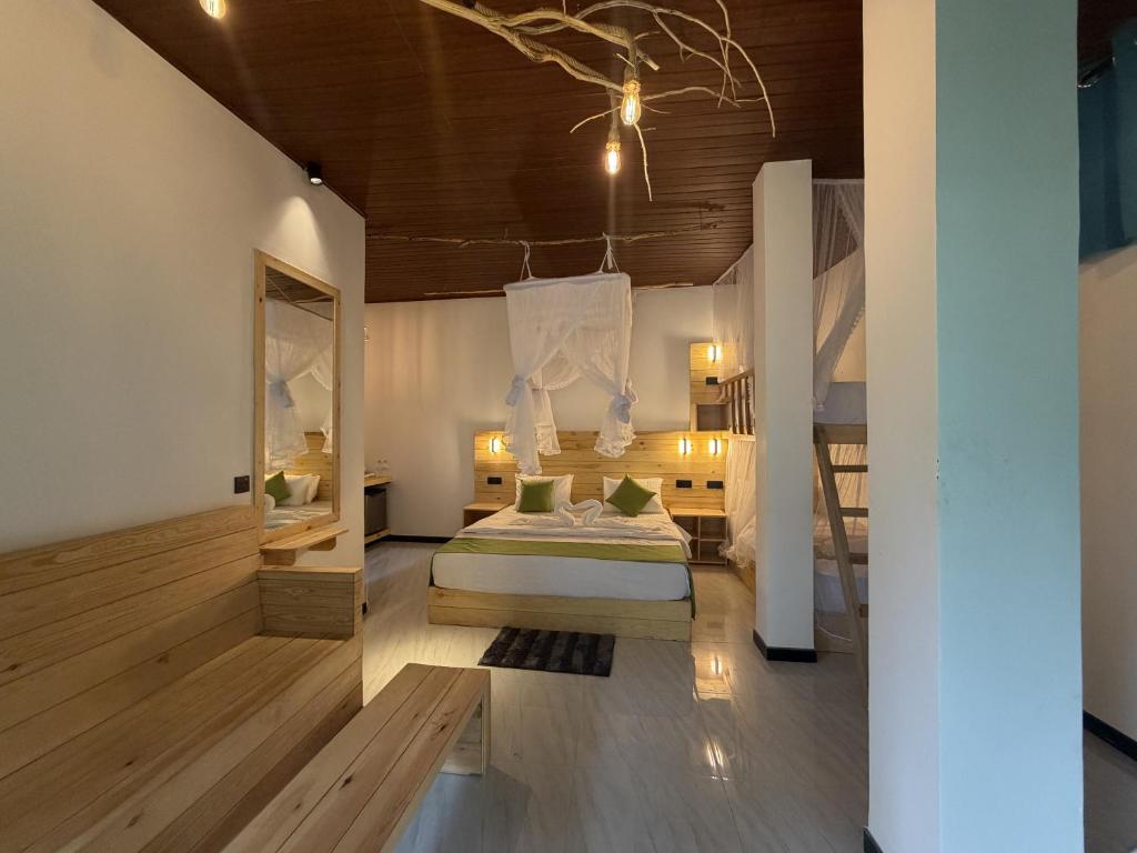 a bedroom with a bed in a room with wooden floors at Rawana River Edge in Ella