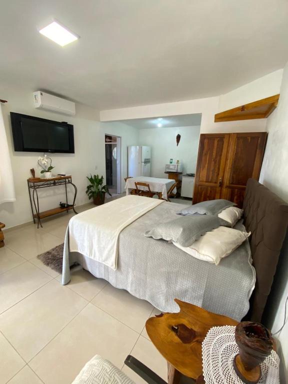 a bedroom with a large bed and a television at Hospedaria Klagemberg in Treze Tílias